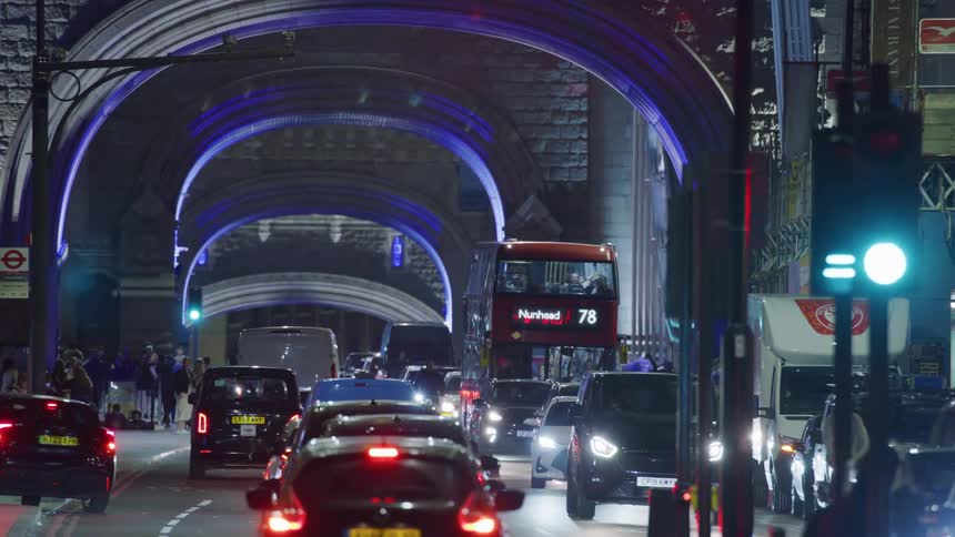 London city street at night cars and double decker bus