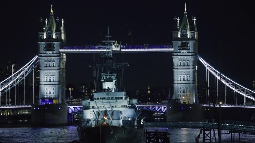 London bridge illuminated with purple lights at night