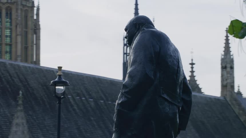 Monument of a person in the center of a metropolis on a cloudy day