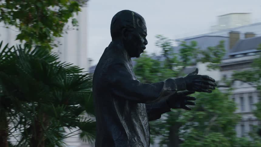A statue in a city park near a road