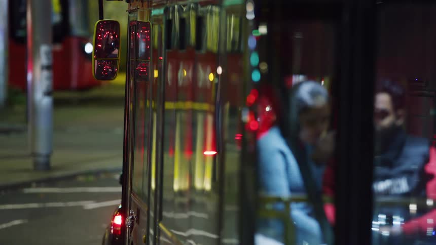 Man and woman inside a public bus stopped in a traffic lane