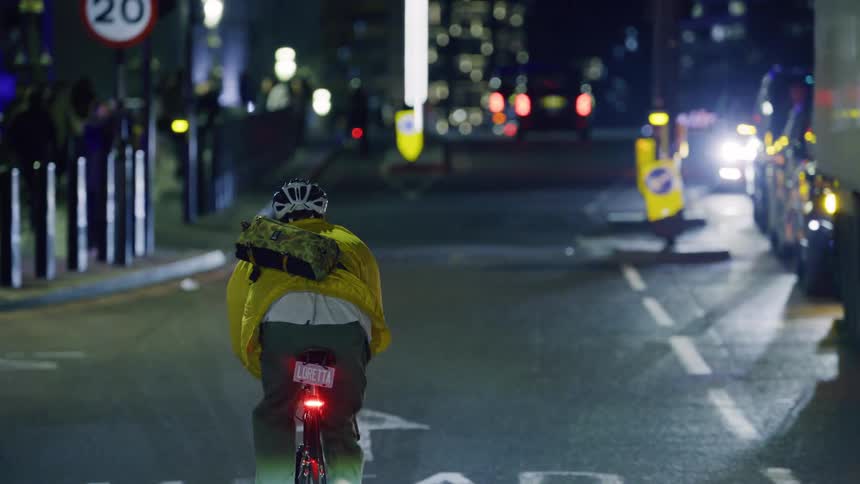 Man cycling on a street at night
