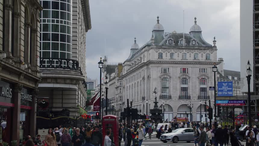 London city street buildings pedestrians and vehicles cloudy day