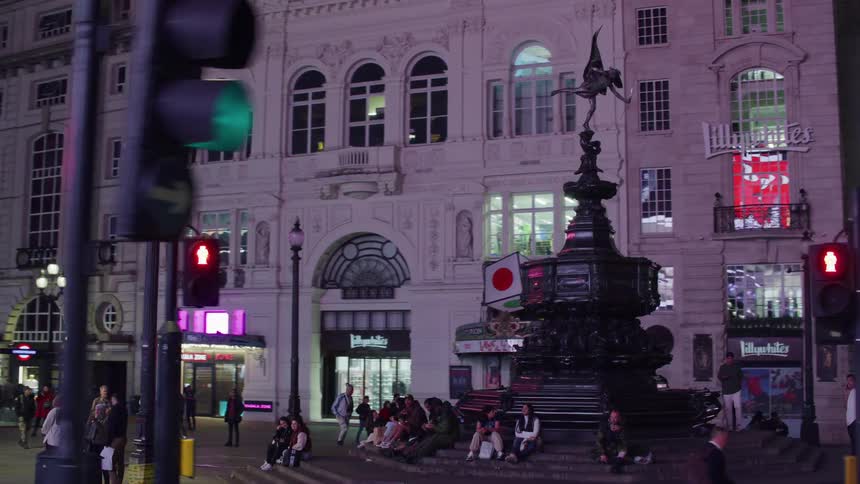 View of a square at night with numerous people in the midst of the city