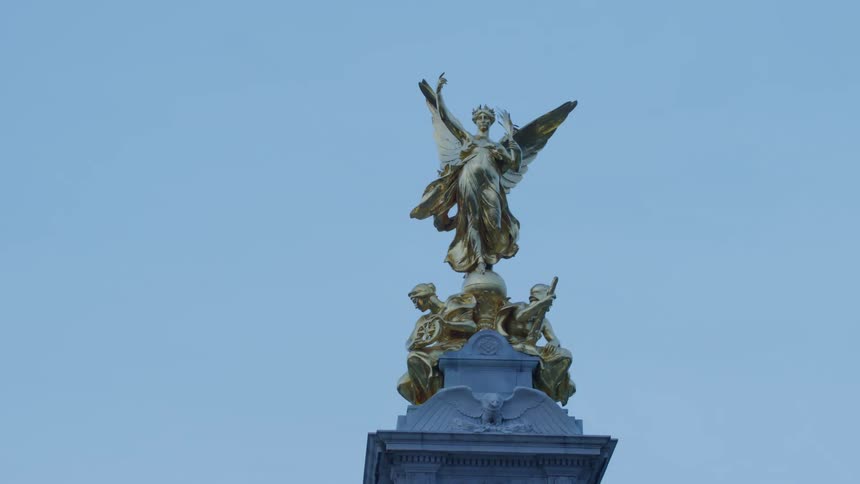 A winged statue sits near street lights