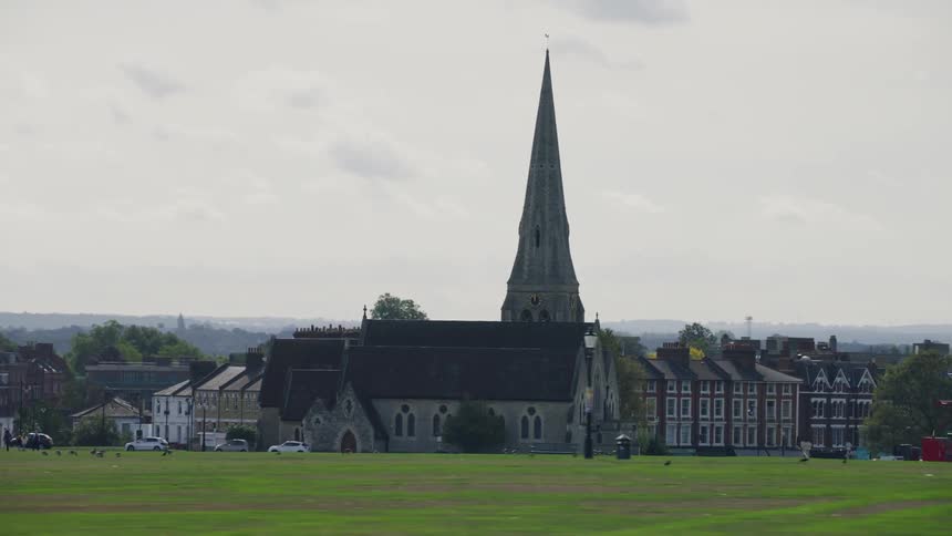 Church with a pointed tower and a half an urban city