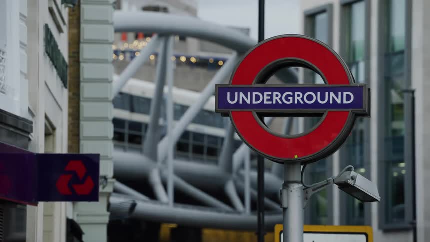 Sign written undergrounds and in the middle of a metropolis with a train passing in the background