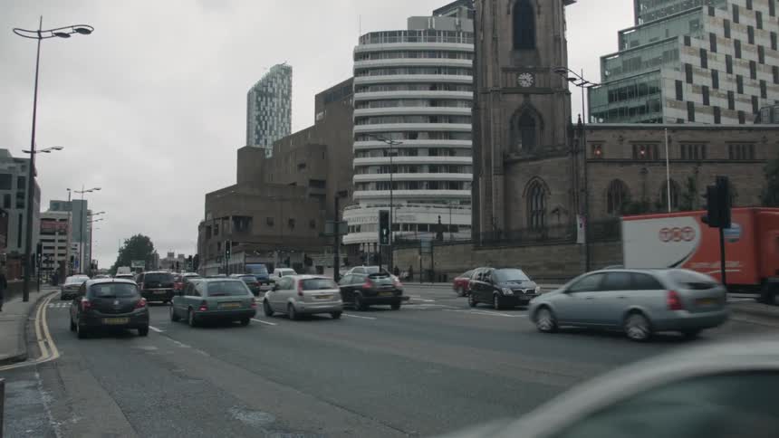 Vehicles travel down a busy city road