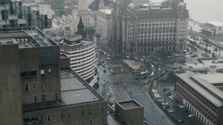 Cars travel along an intersection in a city below