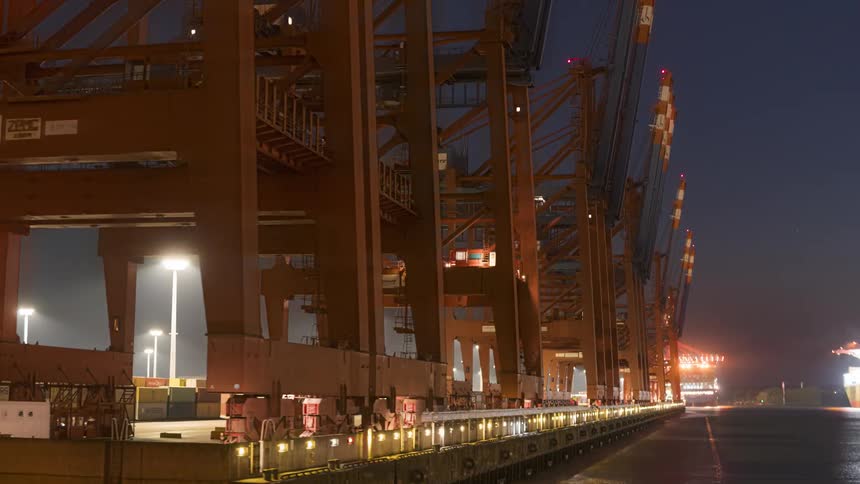 Panorama of platforms in a container logistics center at night in timelapse