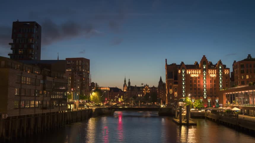 Cityscape with illuminated buildings reflecting on the calm waters of a river
