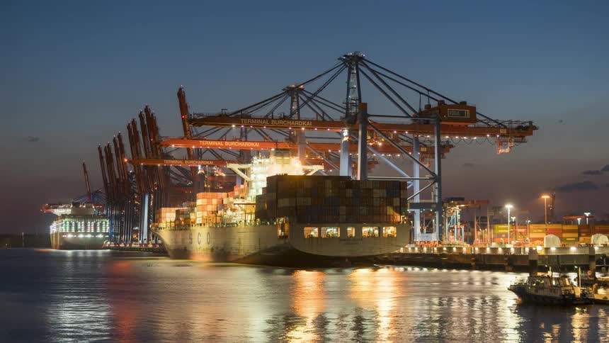 A cargo ship anchored in the city harbor at dusk