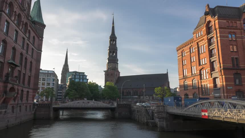 Timelapse of a city with a river in the middle a church and buildings