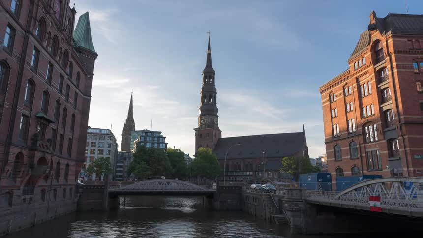 View of a metropolitan city with a small bridge over a river and the waters in timelapse