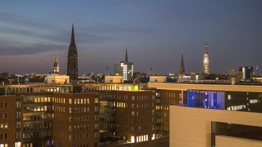 Aerial panorama of residential buildings and towers against a purple evening sky in a timelapse
