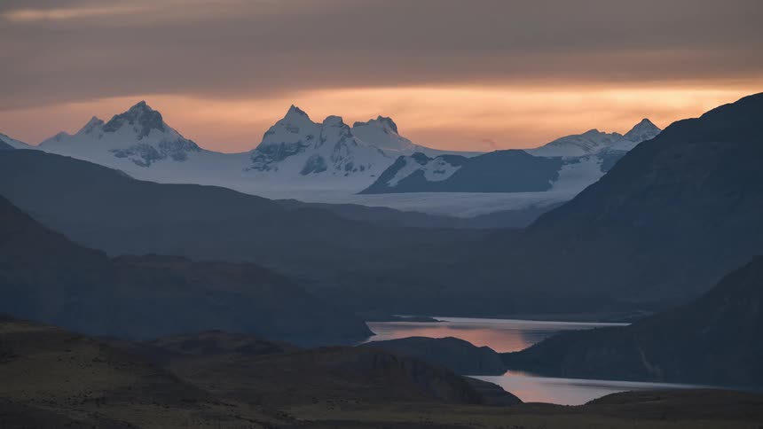 sunset light of glacier topped mountains with lakes in the foreground