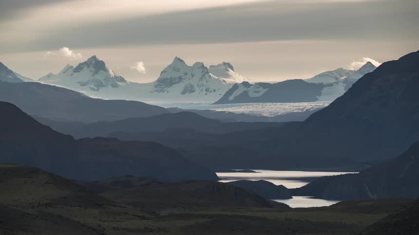 A mountain range sits beyond a chain of lakes