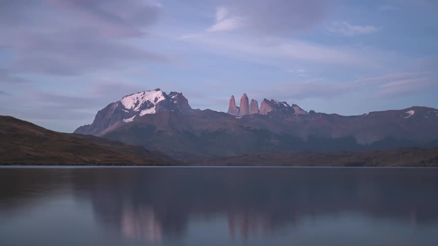 sunrise timelapse of distant mountains by a lake