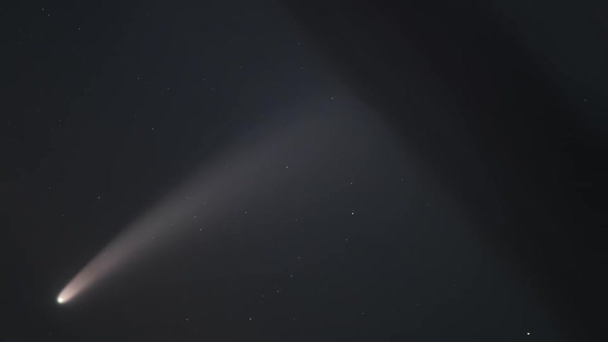 A closeup tracking shot of a comet in the nightsky