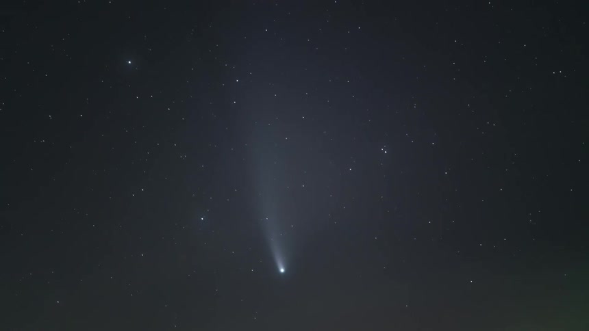 A comet in the dark sky with stars seen shinning in the sky