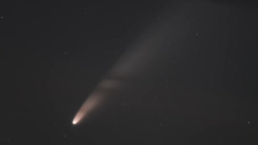 A closeup tracking shot of a comet in the nightsky