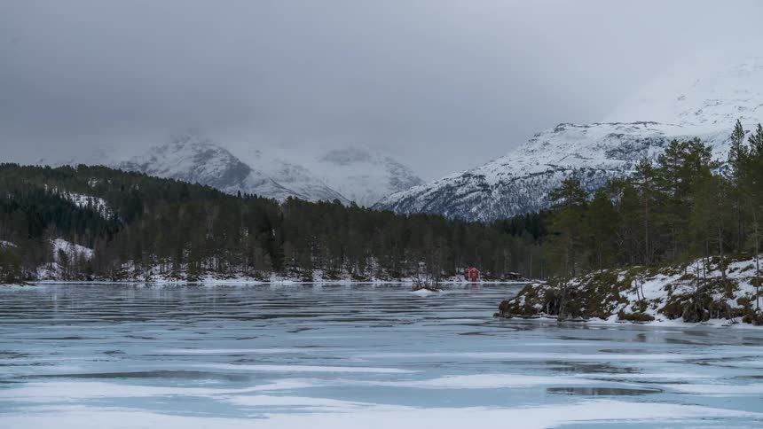 Mountains surround a frozen winter lake