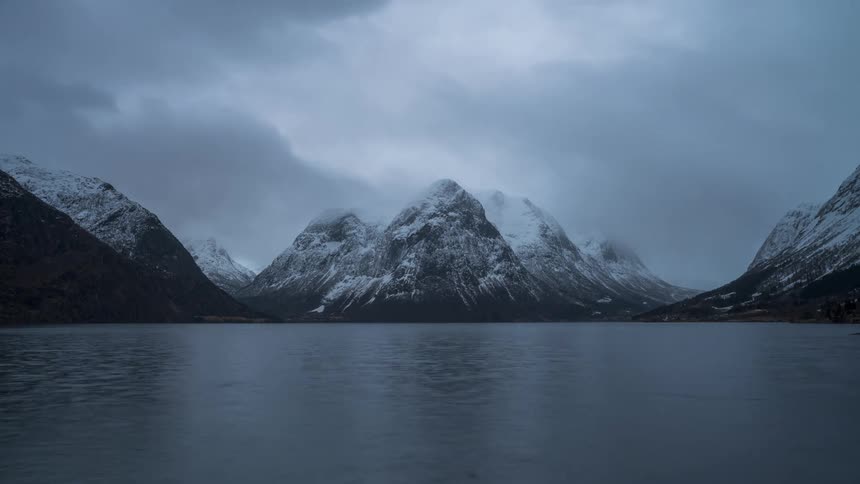 A fjord with a mountain covered in snow during winter
