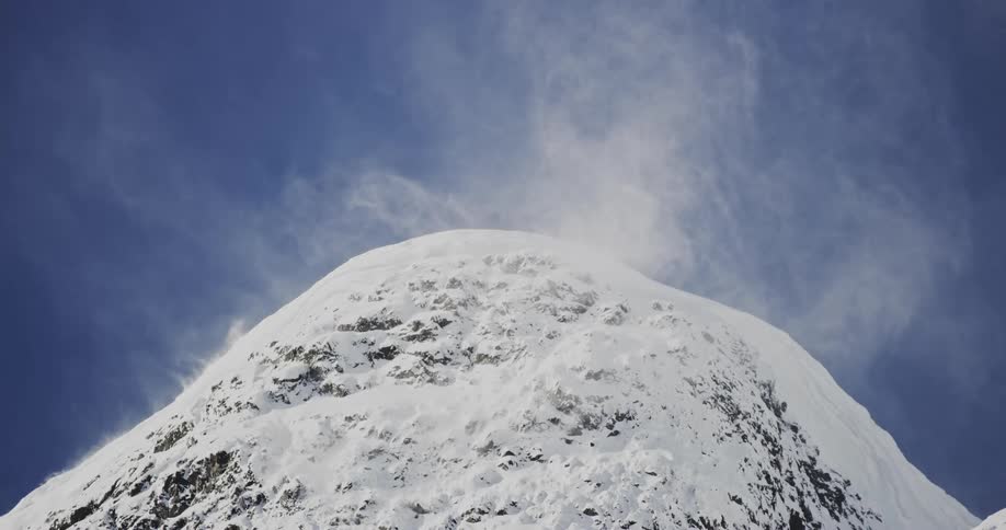 Cliff of a mountain covered in snow with sawdust and slow motion
