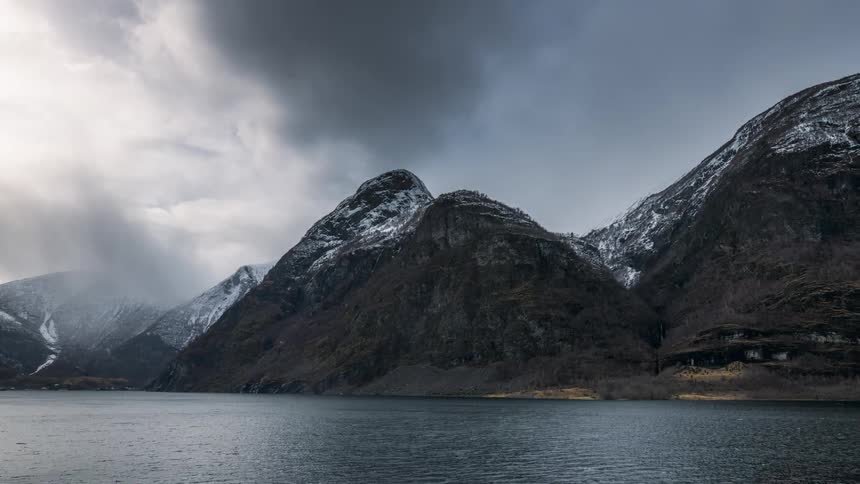 A fjord surrounded by rocky mountain ranges with snow during winter