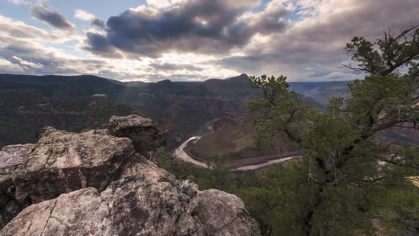 Panorama of canyons and geological rocks on a clear day with clouds in timelapse