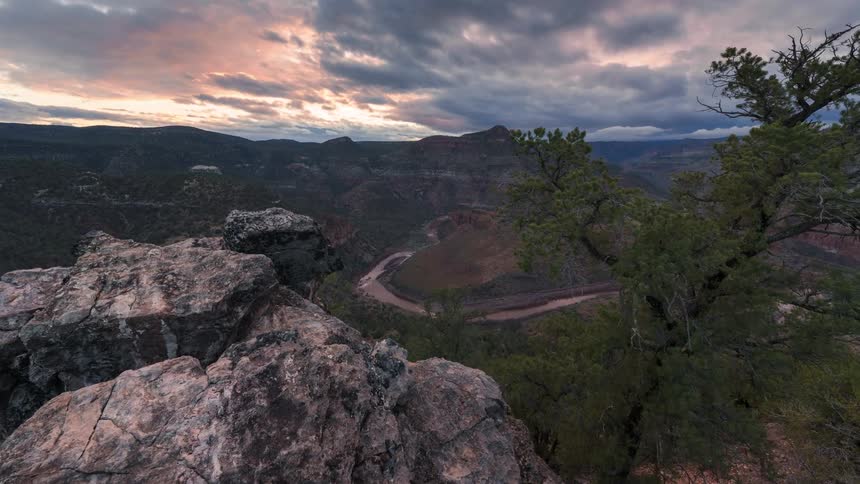 Landscape of a winding river seen from behind a rock on the mountain at sunset