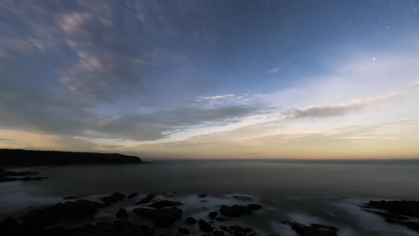 A stary sky at the coast brightening up as the moon rises