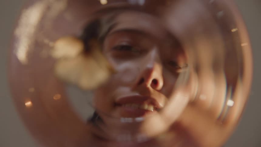 POV as a young woman looks into a fish bowl