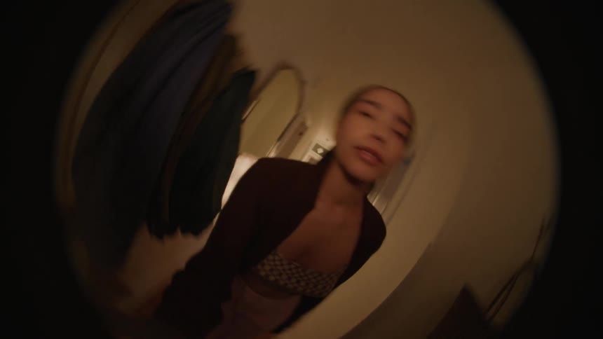 Fisheye POV as Woman walks down the hall and spins camera