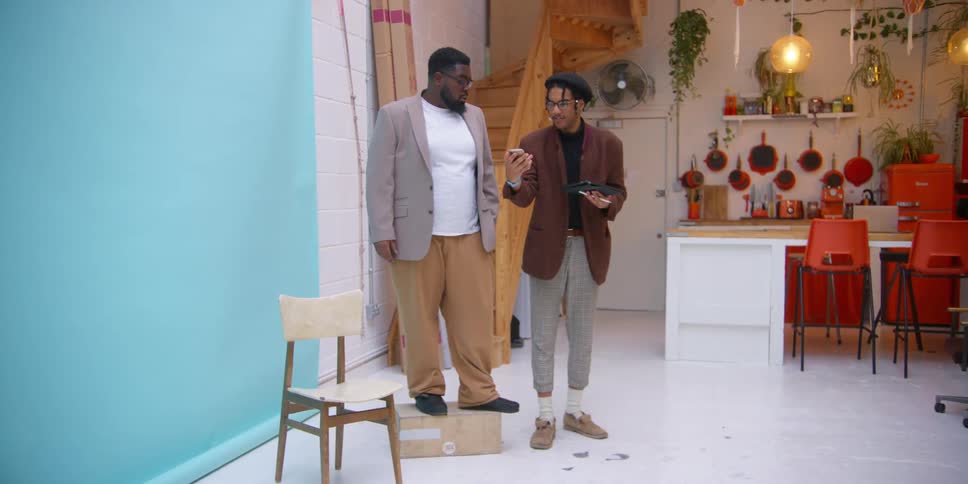 A man takes a picture of another man standing on a box