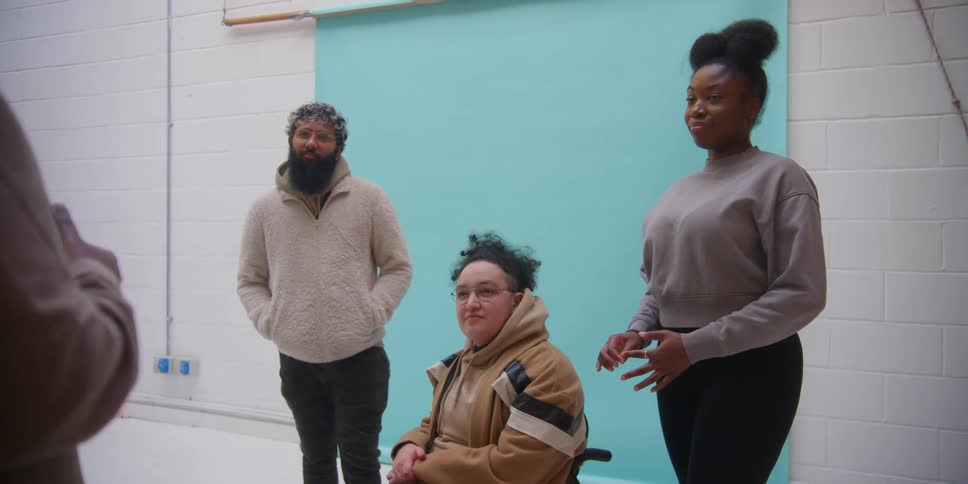 A group of three people listening to someone giving an explanation