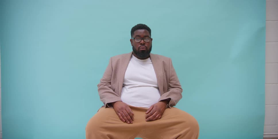 A man sitting in a chair wearing a gray blazer