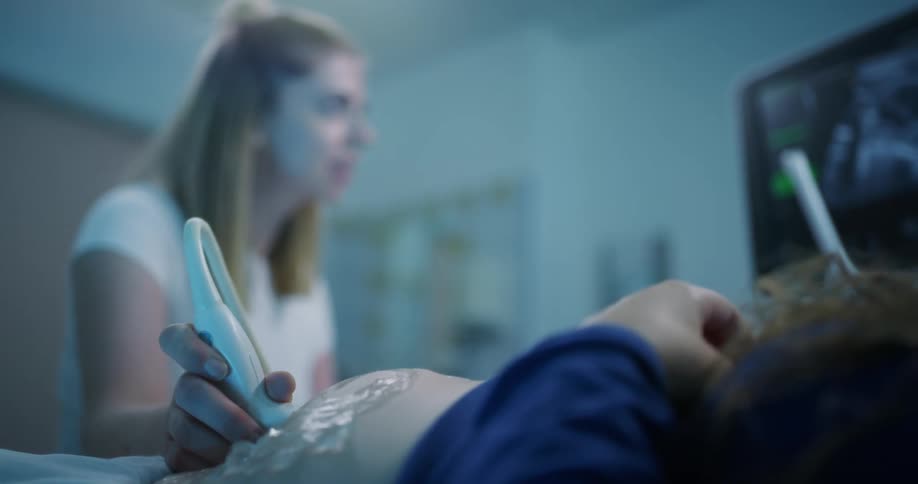 Doctor performing ultrasound on a pregnant womans belly