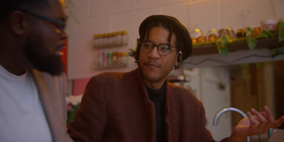 Portrait of two men talking to each other while sitting indoors