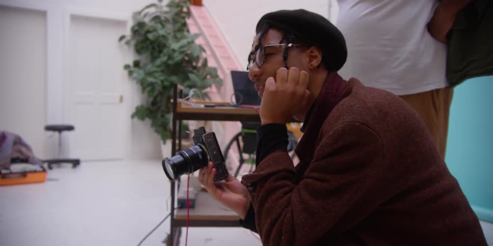 A black man takes pictures in a room