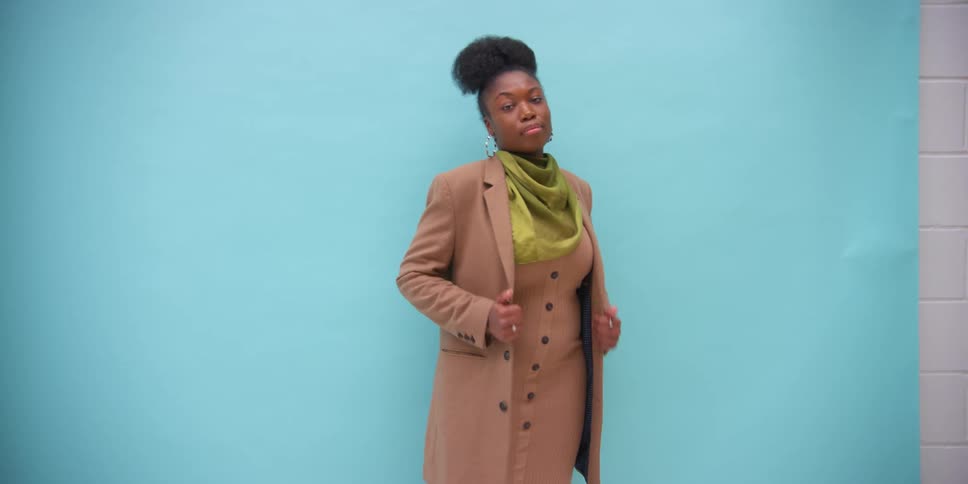 A woman wearing a coat is posing for the camera