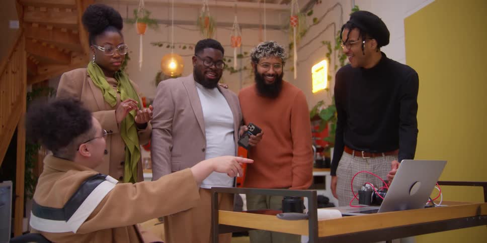 Friends talking around a laptop at the table