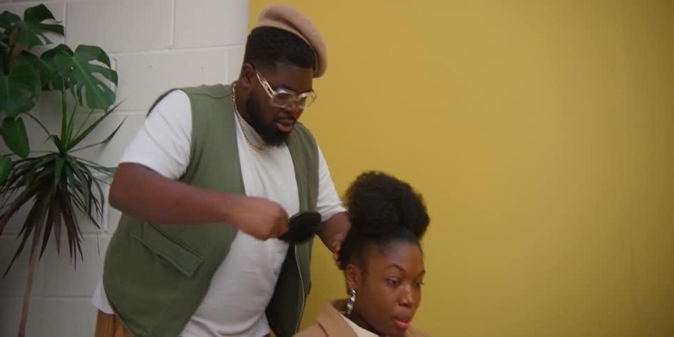 A hairdresser gives a young girls hair a stylish hairstyle