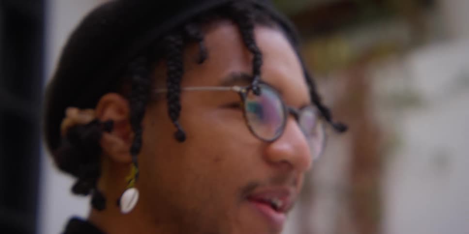 A black man takes a photo and then speaks