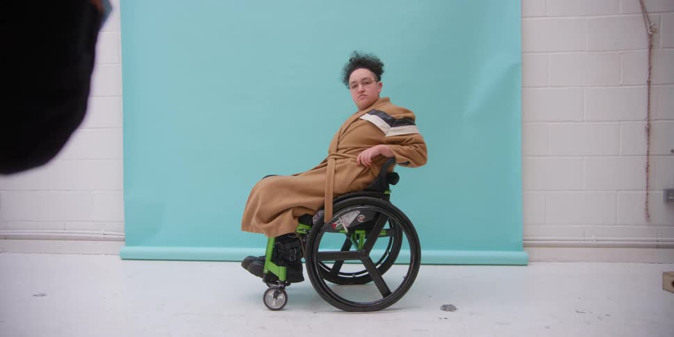 Photographers in a studio taking photos of a person in a wheelchair