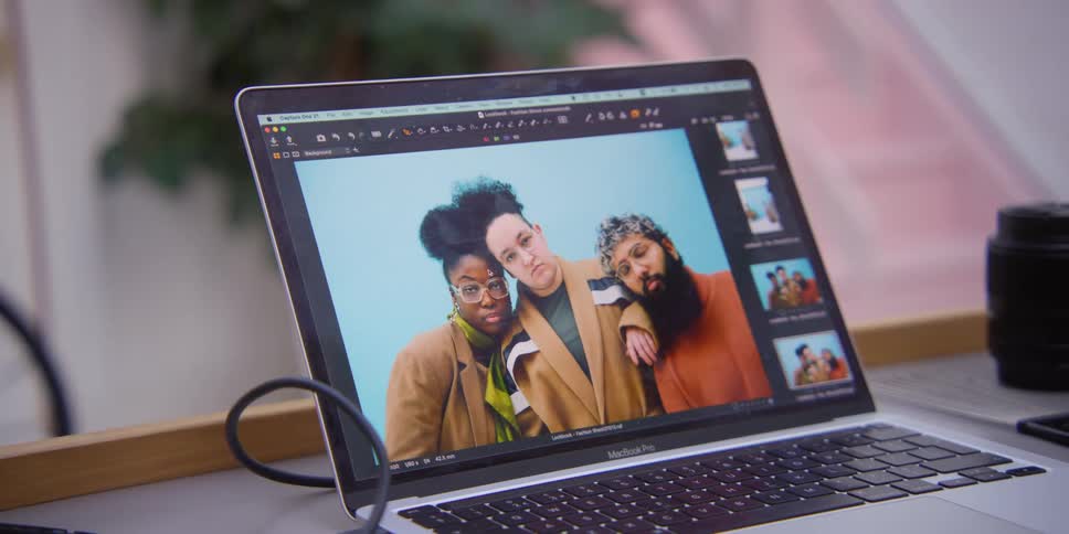 A laptop shows a photo of three models