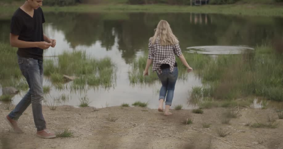 A young woman runs and walks into a pond