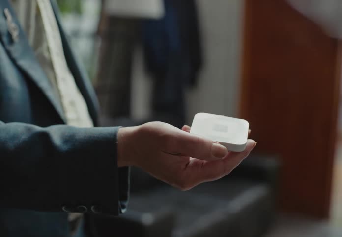 A man holds a scanner so a man can scan his credit card