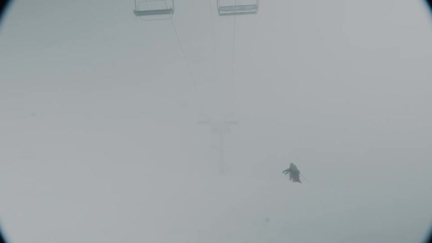 Two people are skiing during a snow storm