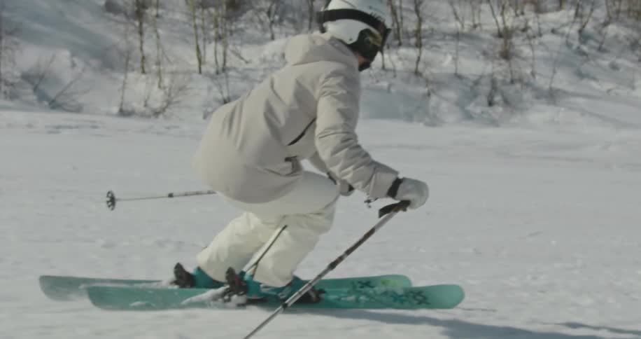 A skier races down a snow covered slope